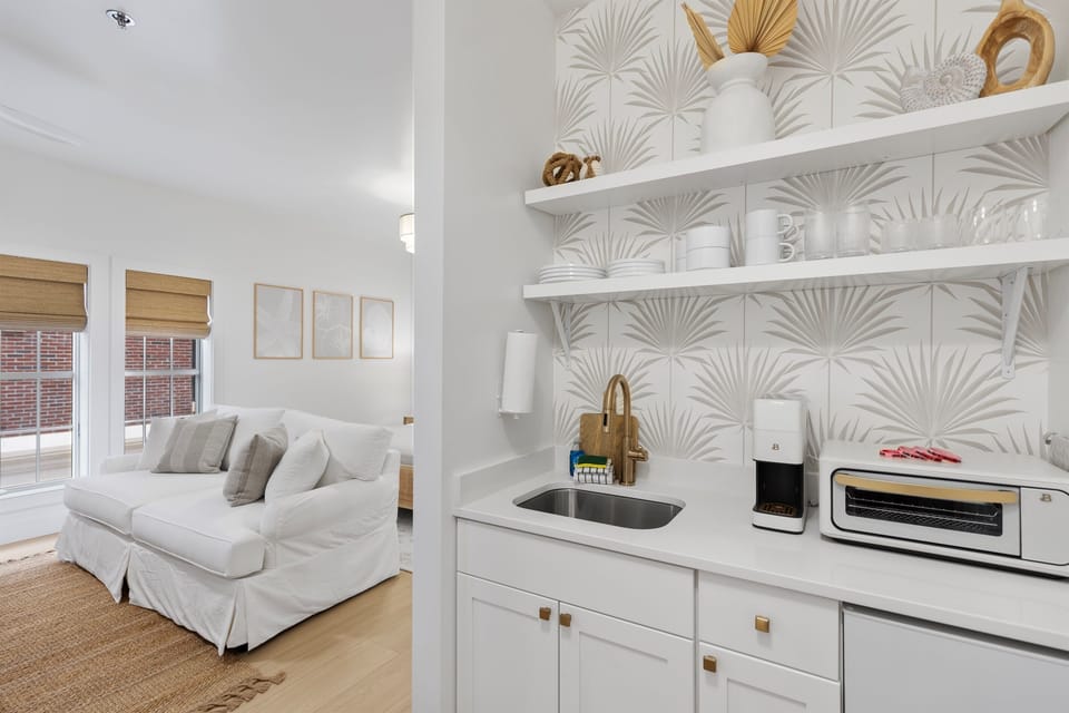 Relax in your bright, stylish space with modern kitchenette featuring elegant palm wallpaper and all essentials for your stay.