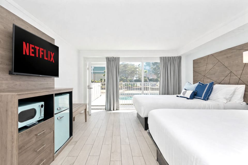 Bright, modern room with two cozy queen beds, a sleek flat-screen TV where guests can enjoy Netflix. Equipped with a mini fridge, microwave, and full curtains for privacy—designed for comfort and a truly restful stay.