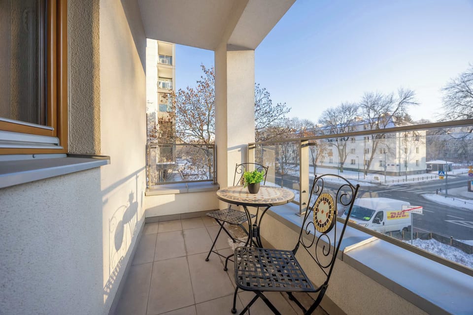 Balcony with outdoor seating and view.