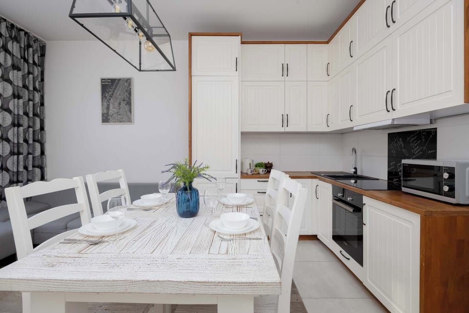 Dining area with table and fully equipped kitchen.
