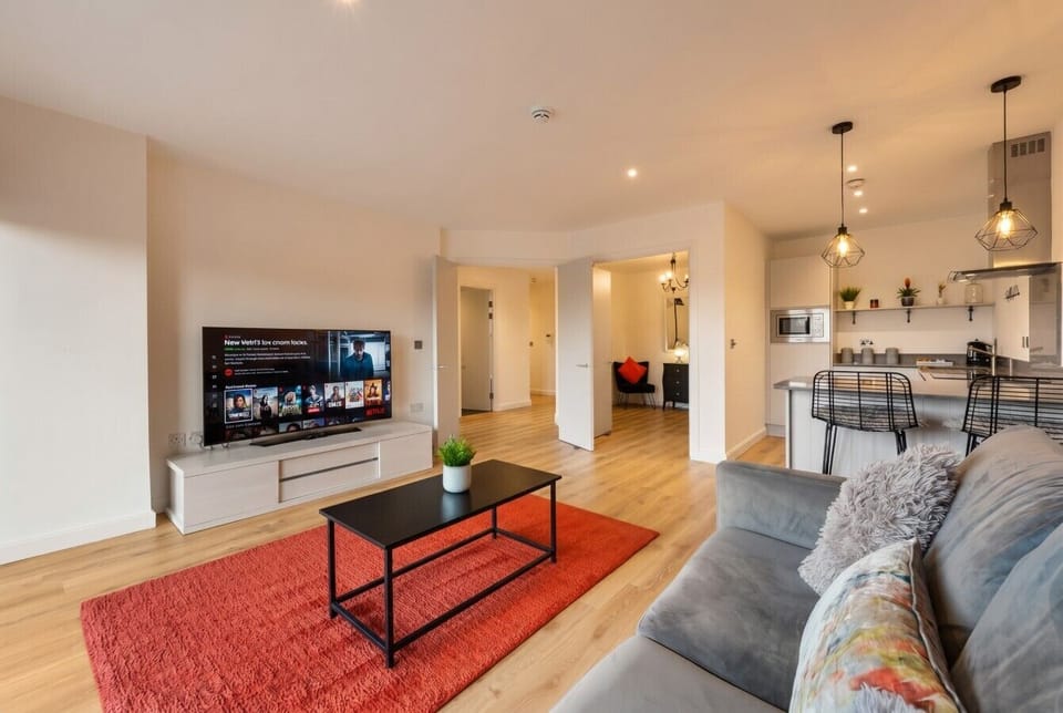 Spacious open-plan lounge with TV, breakfast bar and warm finishes.