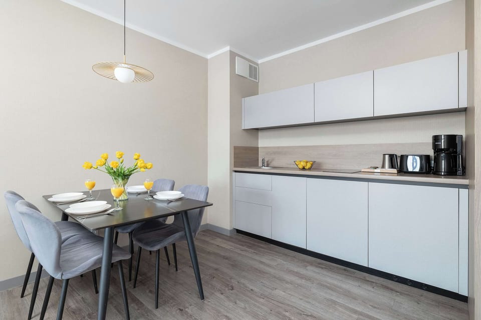 The elegant dining area with a modern table invites you to enjoy shared meals and relaxed mornings with coffee.