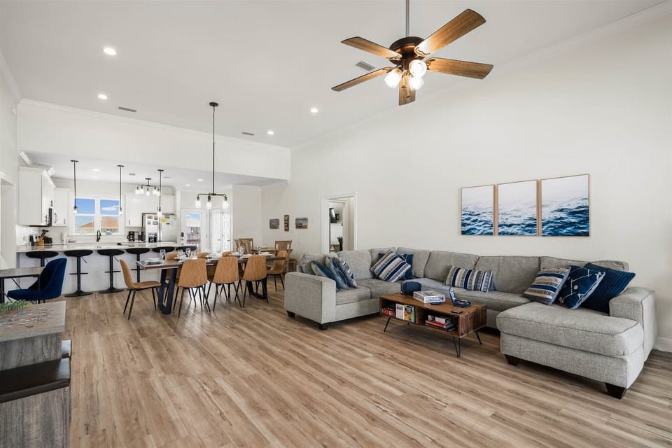 Relax in your spacious open-concept living area with plush sectional seating and coastal touches throughout this bright, modern home.