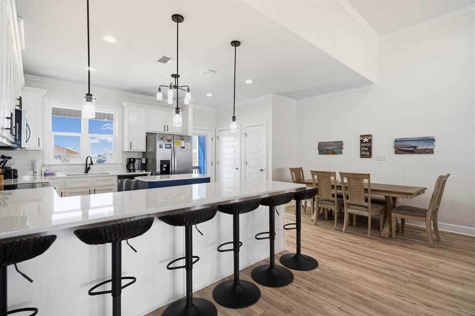 Your open kitchen flows seamlessly into the dining area, where modern pendant lights illuminate the spacious island perfect for morning coffee or evening meals together.