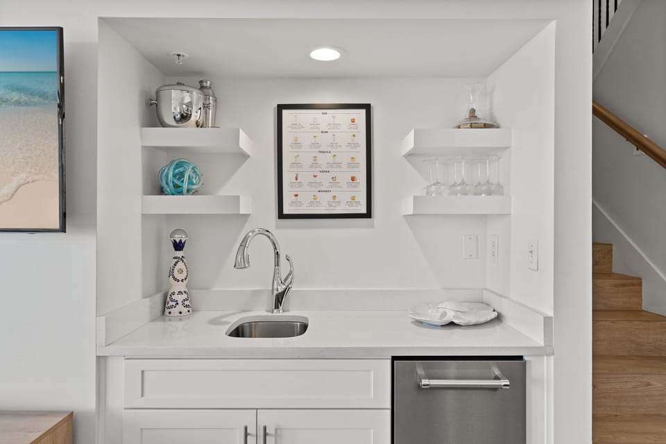 Stylish open shelving complements the sleek wet bar.