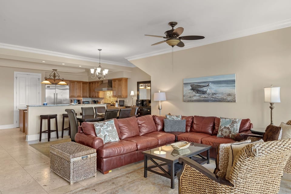 Sink into plush leather seating while coastal breezes flow through your open-concept living space, where kitchen and comfort merge seamlessly.
