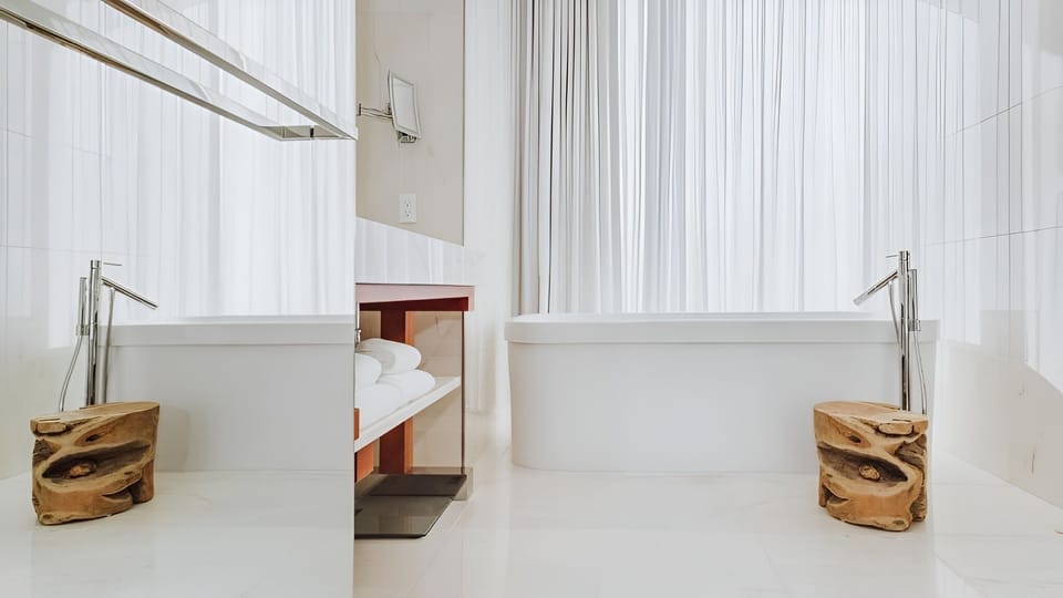 Soak slowly in a serene tub behind airy curtains.