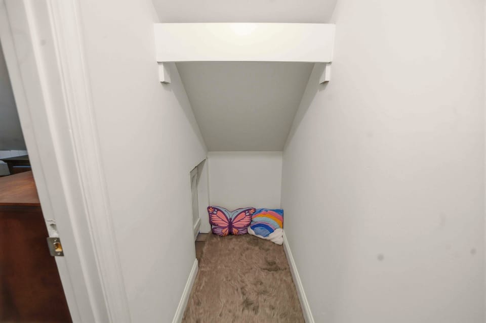 Your cozy storage nook provides convenient space to tuck away beach gear, with colorful pillows adding a playful touch to the clean design.