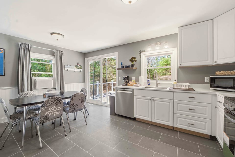Cook your favorite meals in this bright, fully-equipped kitchen with stainless steel appliances and dining space overlooking peaceful trees.