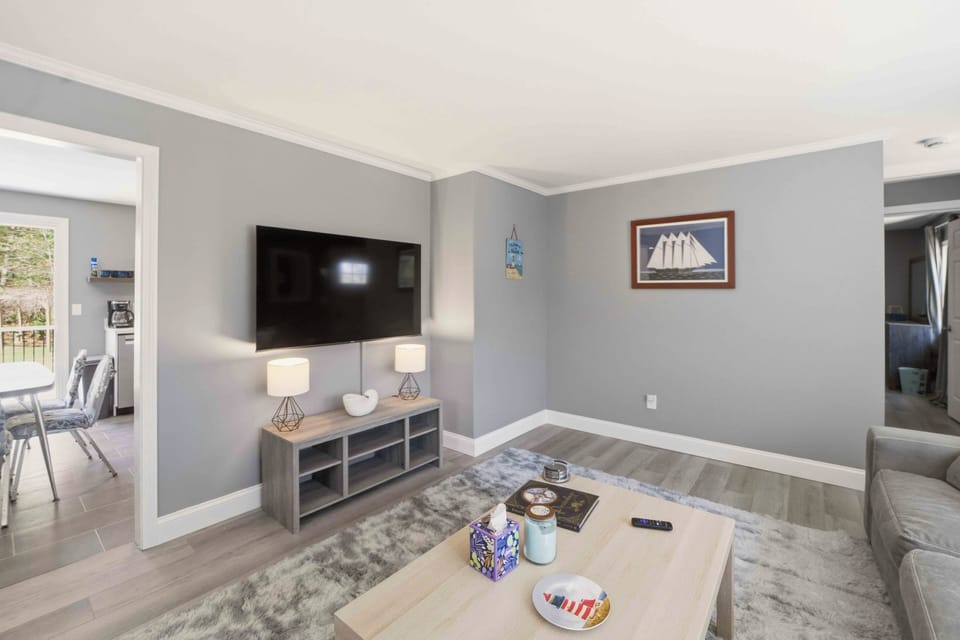 Sink into plush seating while your favorite shows play on the wall-mounted TV in this cozy living room designed for relaxation.