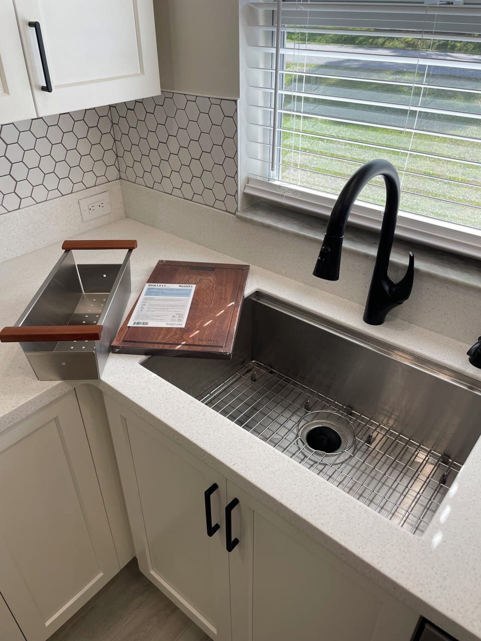 Stainless steel sink with cutting board, capture basket, and garbage disposal