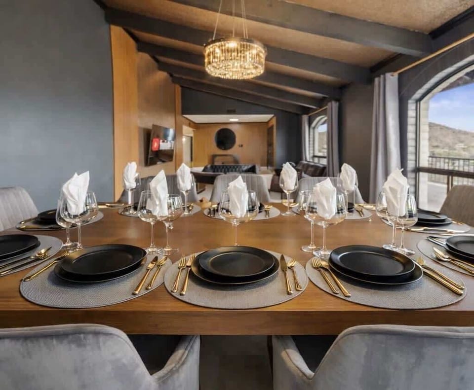 A dining space designed for long evenings—vaulted beams, a statement chandelier, and an oversized table that brings everyone together without feeling formal.