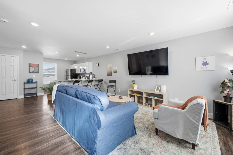 Bright open-plan lounge with huge TV, modern kitchen and island seating