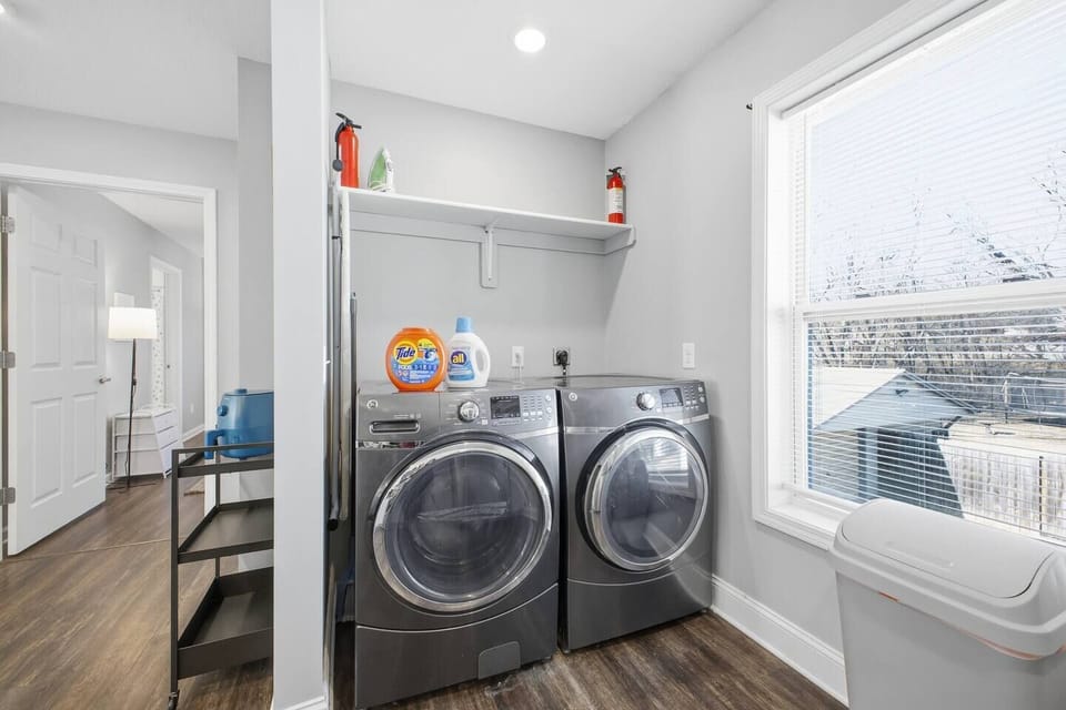 Bright laundry with modern W/D, supplies and storage included