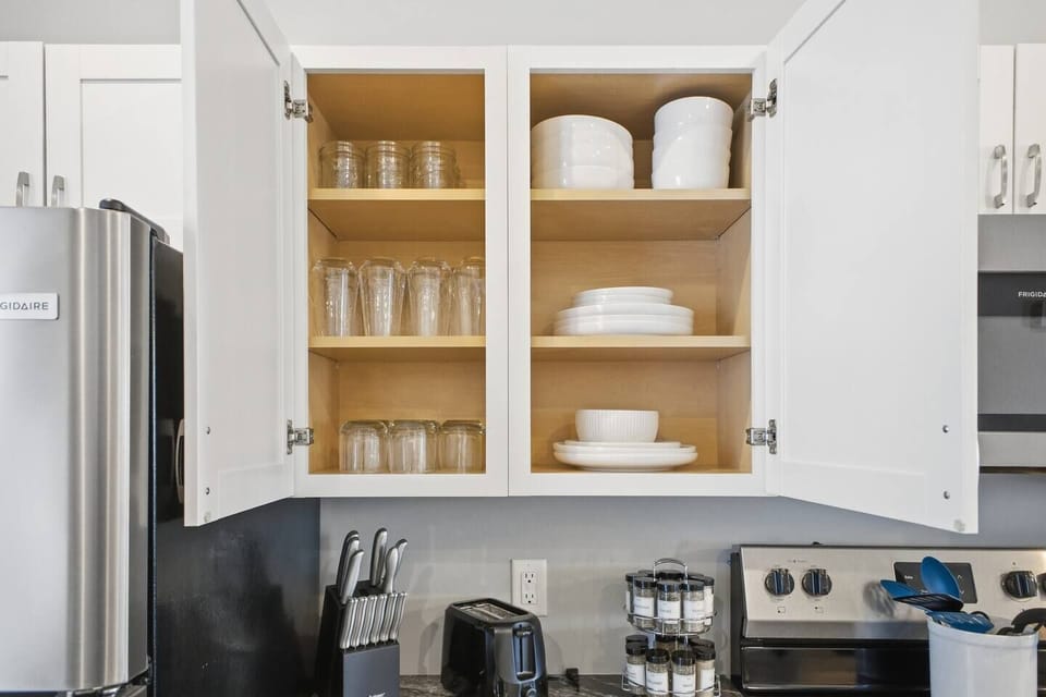 Fully stocked kitchen with dishes, spices, and modern appliances.