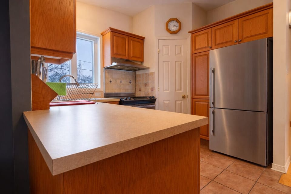 Functional kitchen with central island and stainless steel refrigerator