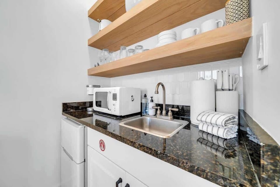 Kitchenette in condo features a microwave, toaster, Keurig coffee maker, mini fridge/freezer, and dishes!