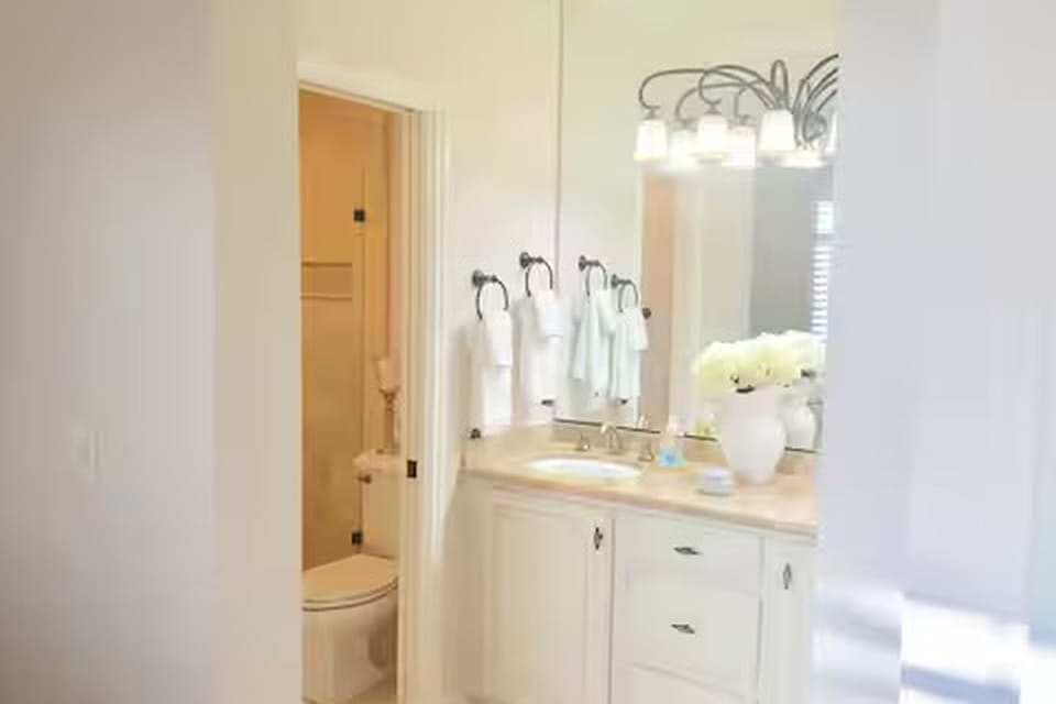 Dual sinks in master closet with privacy door to toilet