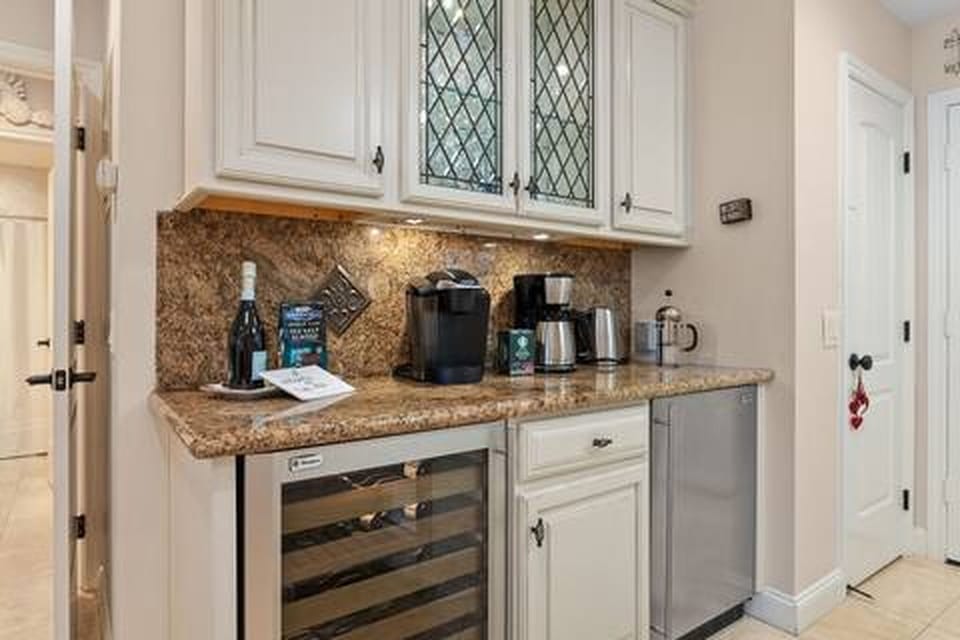 Coffee and wine bar with wine refrigerator and extra small refrigerator.  
