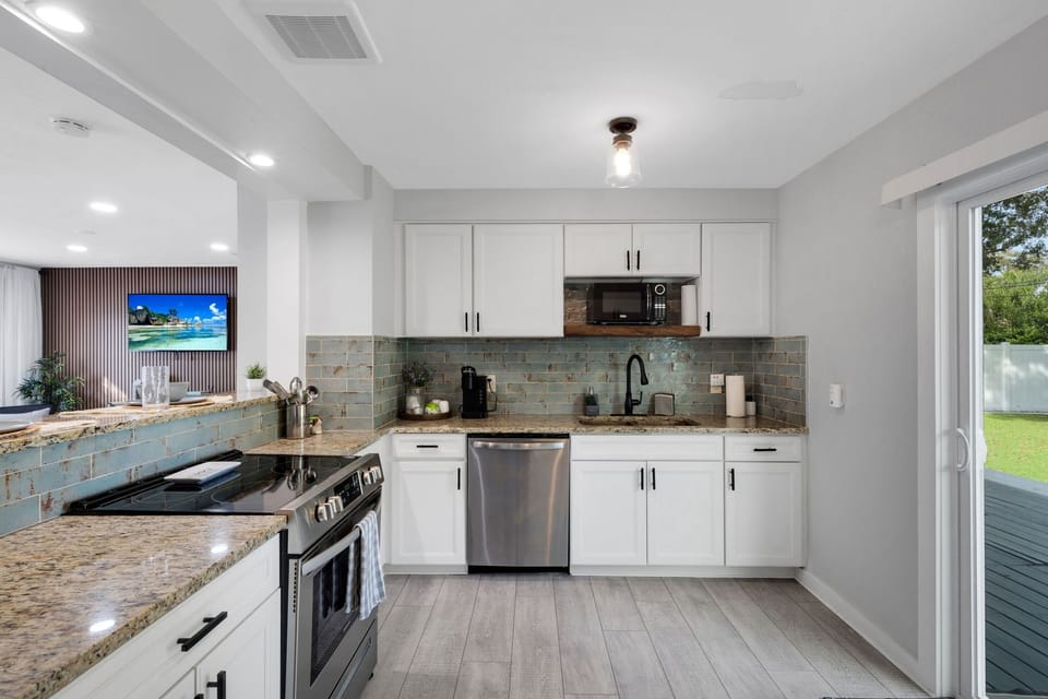 Our fully equipped kitchen includes a fridge, microwave, stove, oven, dishwasher, coffee maker, cooking utensils, glasses, dishware, and silverware.