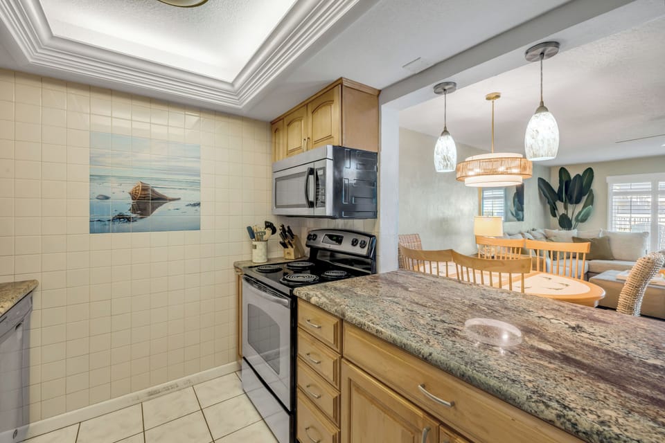 The kitchen counter provides ample prep space and opens seamlessly to the dining and living areas, creating a bright and connected layout ideal for entertaining