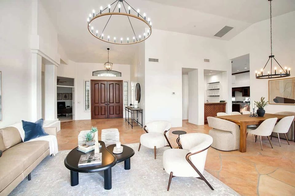 Formal living area with modern seating and a large open floor space connected to the formal dining area for 7 and bar area. Easy access to the private backyard.