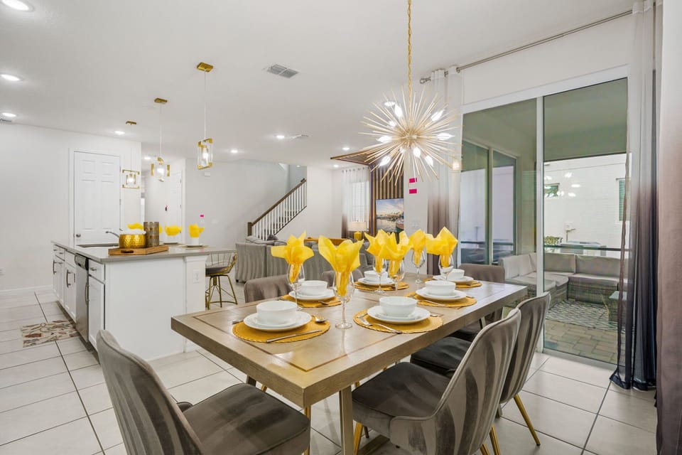 Dine in style at the wooden table for eight under a striking starburst chandelier-steps from the kitchen and patio for easy entertaining and family meals.