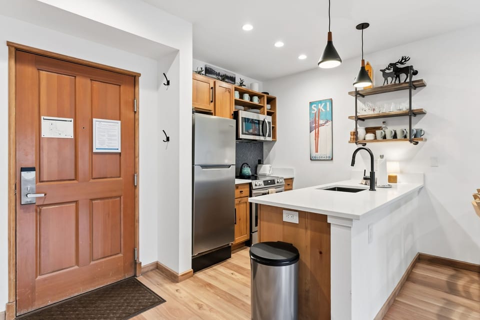 Your fully equipped kitchen awaits with sleek marble countertops, stainless steel appliances, and charming open shelving perfect for culinary adventures.