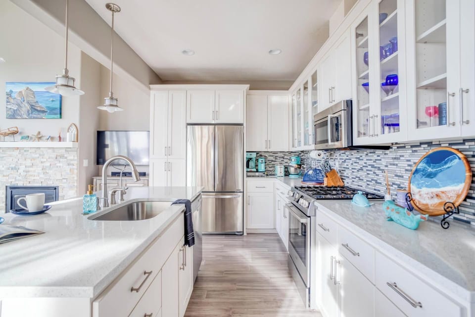 Your gourmet kitchen awaits with gleaming quartz counters, stainless appliances, and ocean-themed touches that inspire coastal cooking adventures.