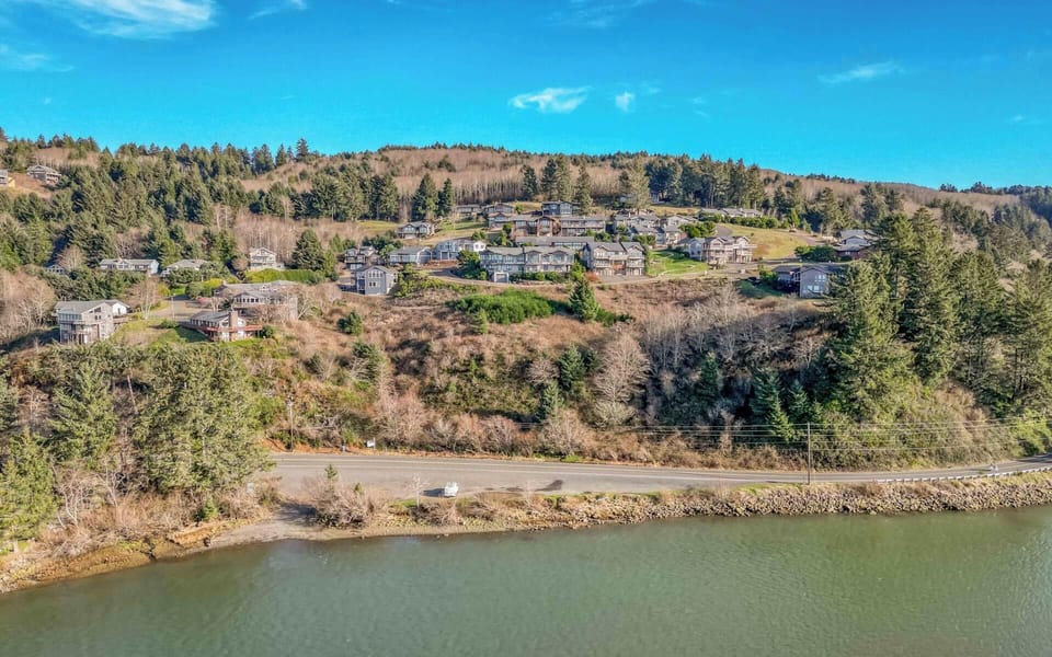 Scenic hillside neighborhood overlooks tranquil waters, offering peaceful residential setting surrounded by natural landscape and rolling hills.