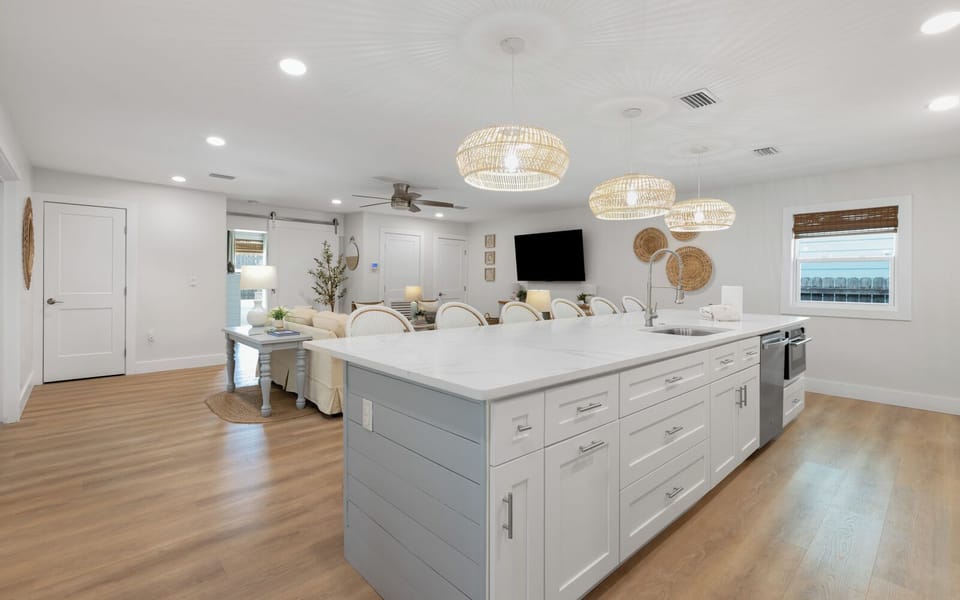 Gather around your spacious kitchen island where coastal charm meets modern comfort - perfect for morning coffee and evening conversations.