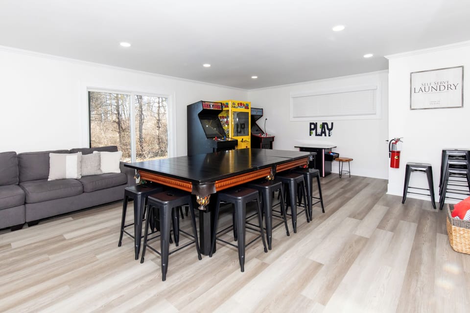 Your personal game room awaits with vintage arcade fun, pool table, and cozy seating for the perfect entertainment retreat.