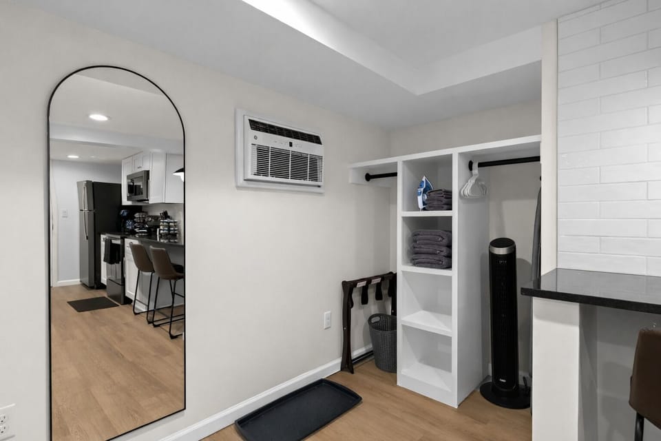 Smart storage and prep area with open shelving, hanging space, and a full-length mirror—perfect for staying organized and settling in with ease.