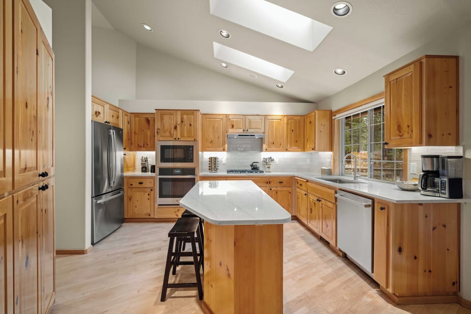 Your spacious kitchen features warm wood cabinetry, modern appliances, and a central island perfect for cooking memorable meals together.