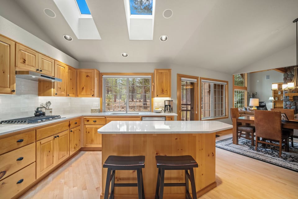 Your spacious kitchen welcomes you with warm wood cabinetry, bright skylights, and a center island perfect for cooking together.