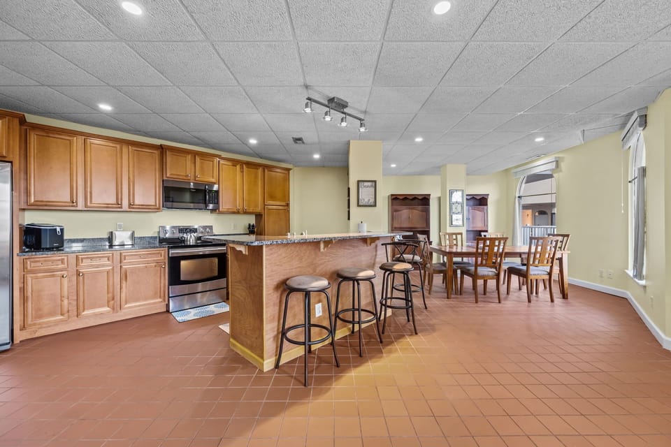 Open-concept kitchen and dining layout with wide circulation space, bar seating, and an easy, step-free flow throughout