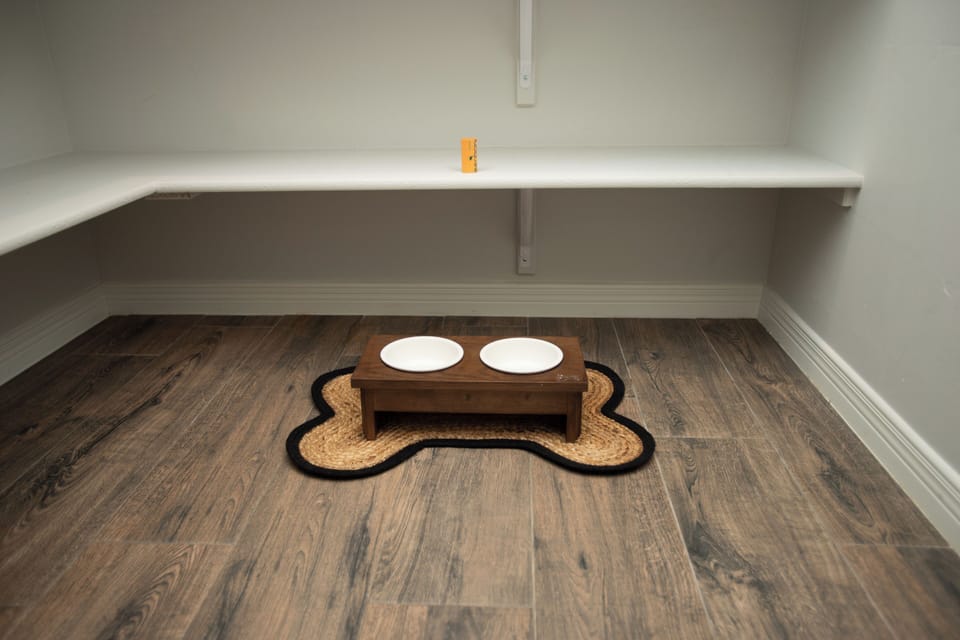 Pantry area includes dog bowls with disposable waste bags