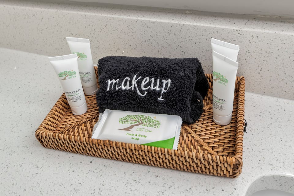 Full, modern bathroom with a shower and bathtub, toilet, and sink. Equipped with essential bathroom amenities including shampoo, conditioner, shower gel, hair dryer, and fresh towels for a comfortable, hassle-free stay.
