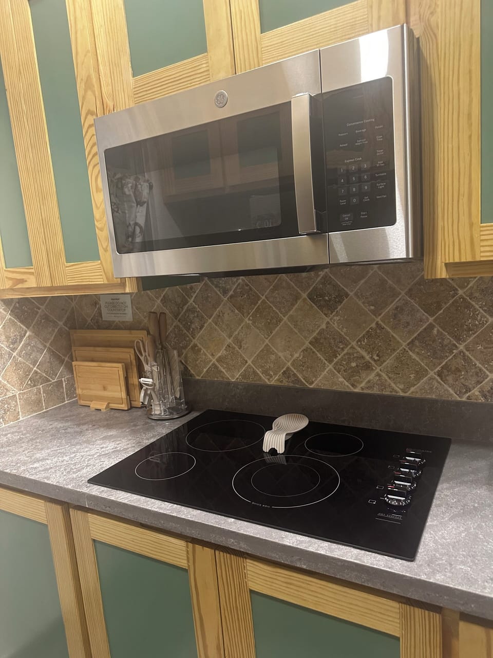 GE stainless steel microwave above stove top.