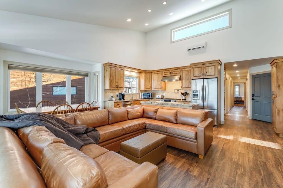 Large leather sectional and open kitchen.