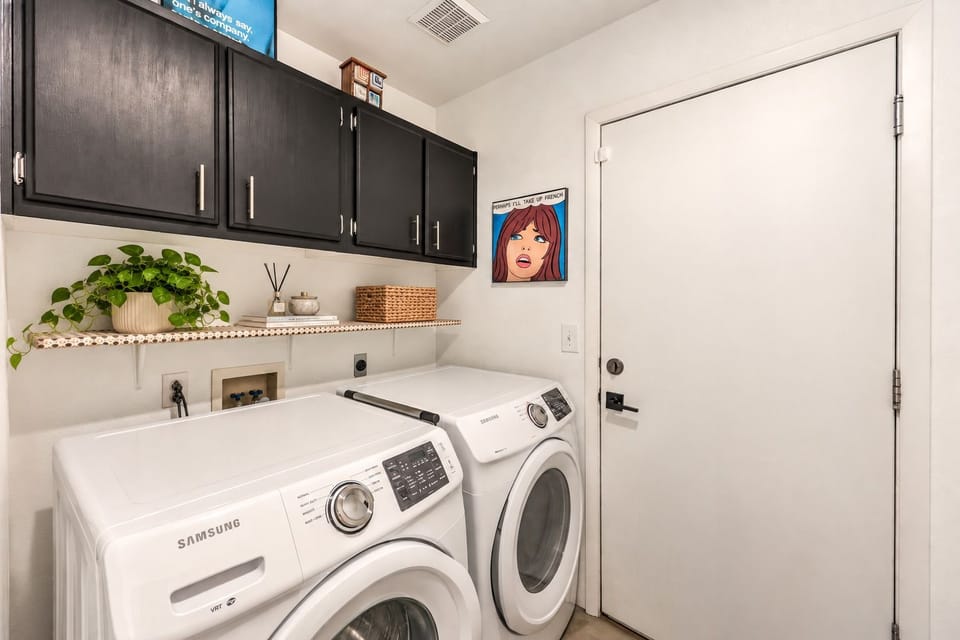 Bright laundry room with full-size washer/dryer and stylish storage