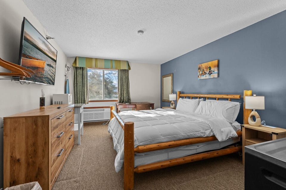 Private king bedroom with warm wood accents, plush bedding, and a cozy Northwoods feel