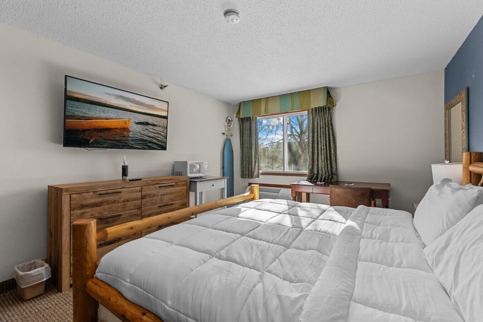 Private king bedroom with warm wood accents, plush bedding, and a cozy Northwoods feel