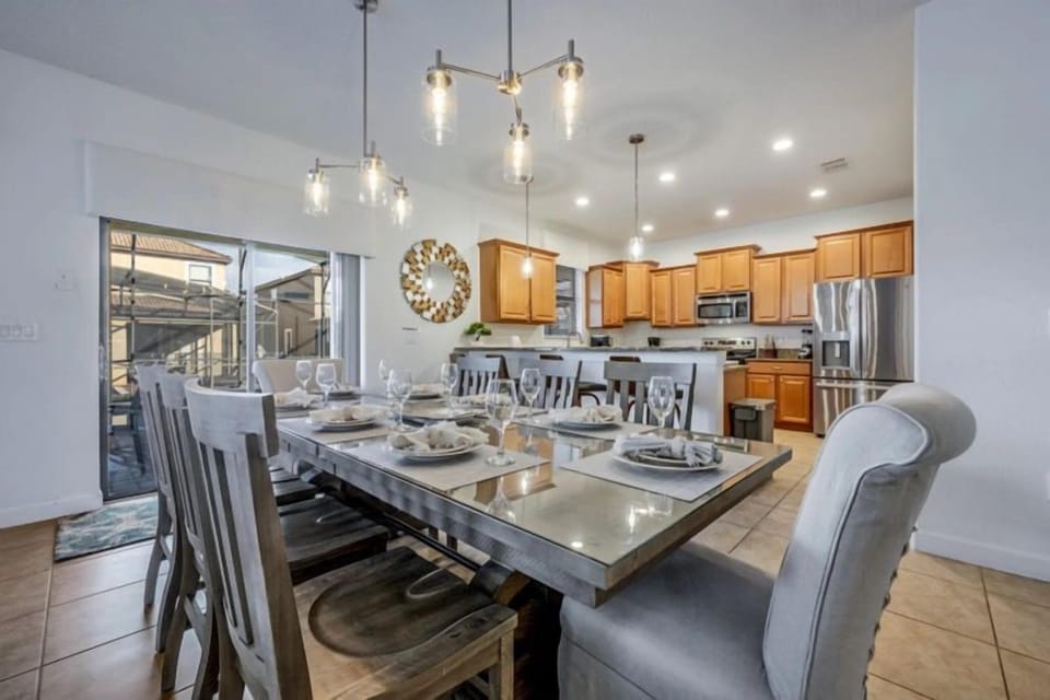Bright dining area with seating for groups, modern kitchen, and easy access to the pool patio.