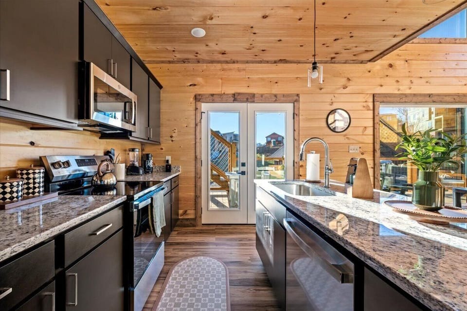 Your fully-equipped kitchen features granite countertops, stainless appliances, and warm wood accents perfect for preparing memorable meals during your stay.