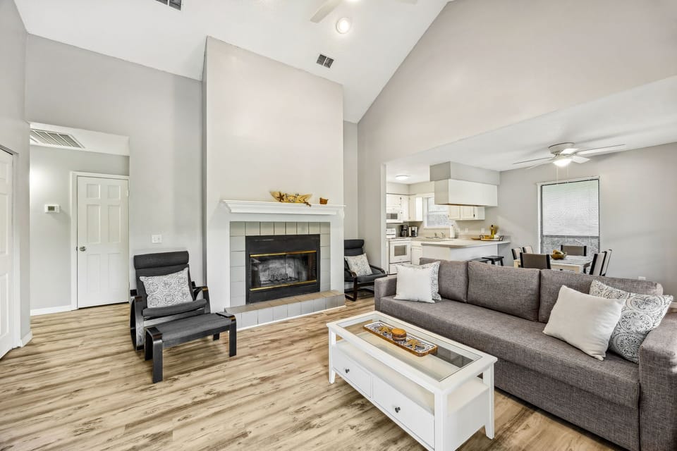 Unwind in your elegant living space with cozy fireplace, modern furnishings, and open kitchen - perfect for relaxing evenings.