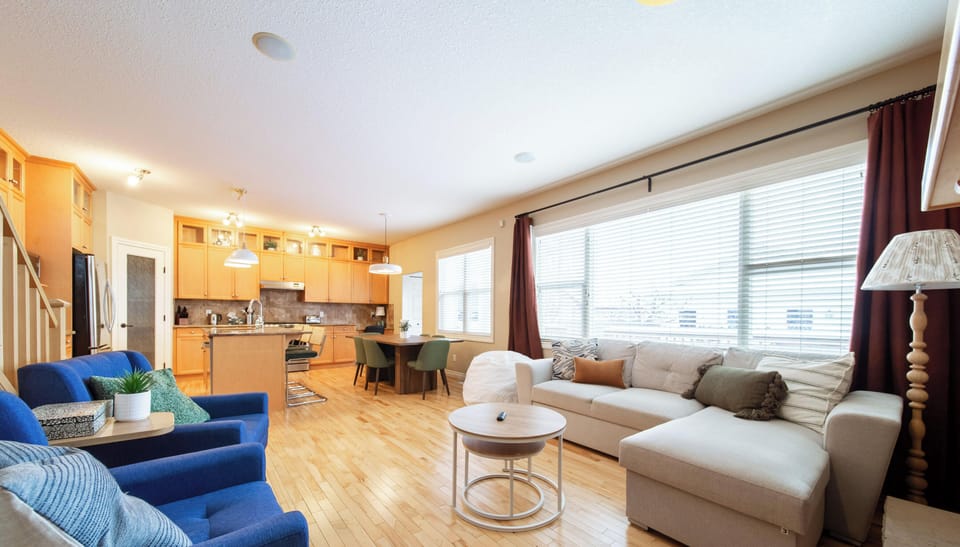 Bright open-concept room with fireplace, hardwood floors, and plush seating