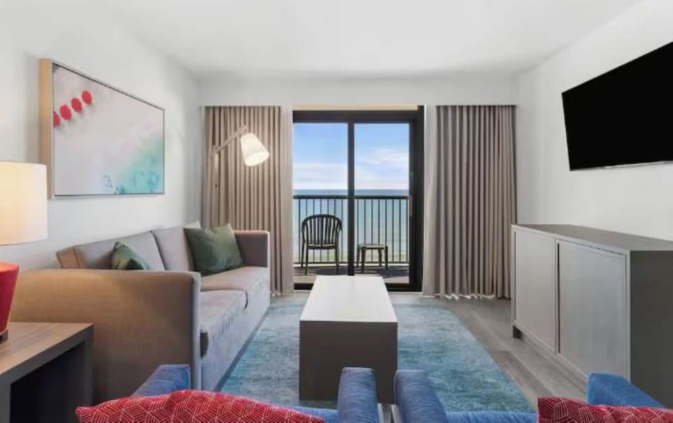 Lounge with sunrise views framed by floor-to-ceiling glass doors.