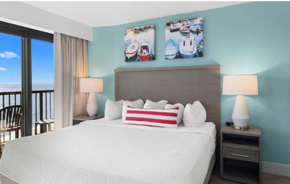 Unwind into crisp linens with a soothing ocean peek.