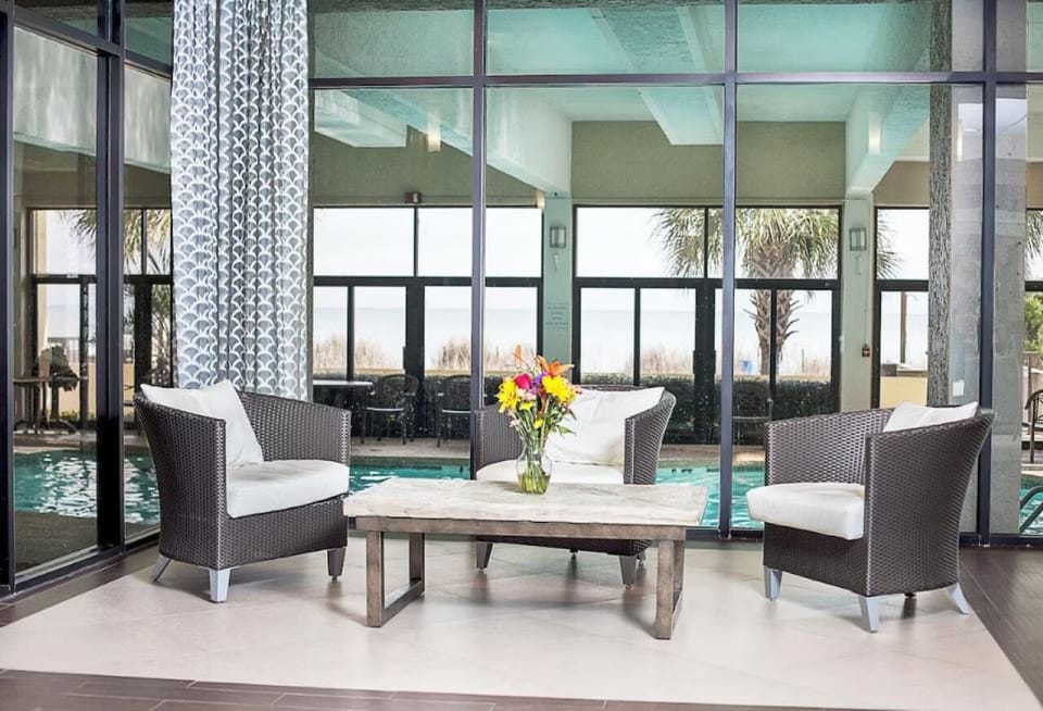 Unwind poolside indoors, basking in light-filled coastal calm.
